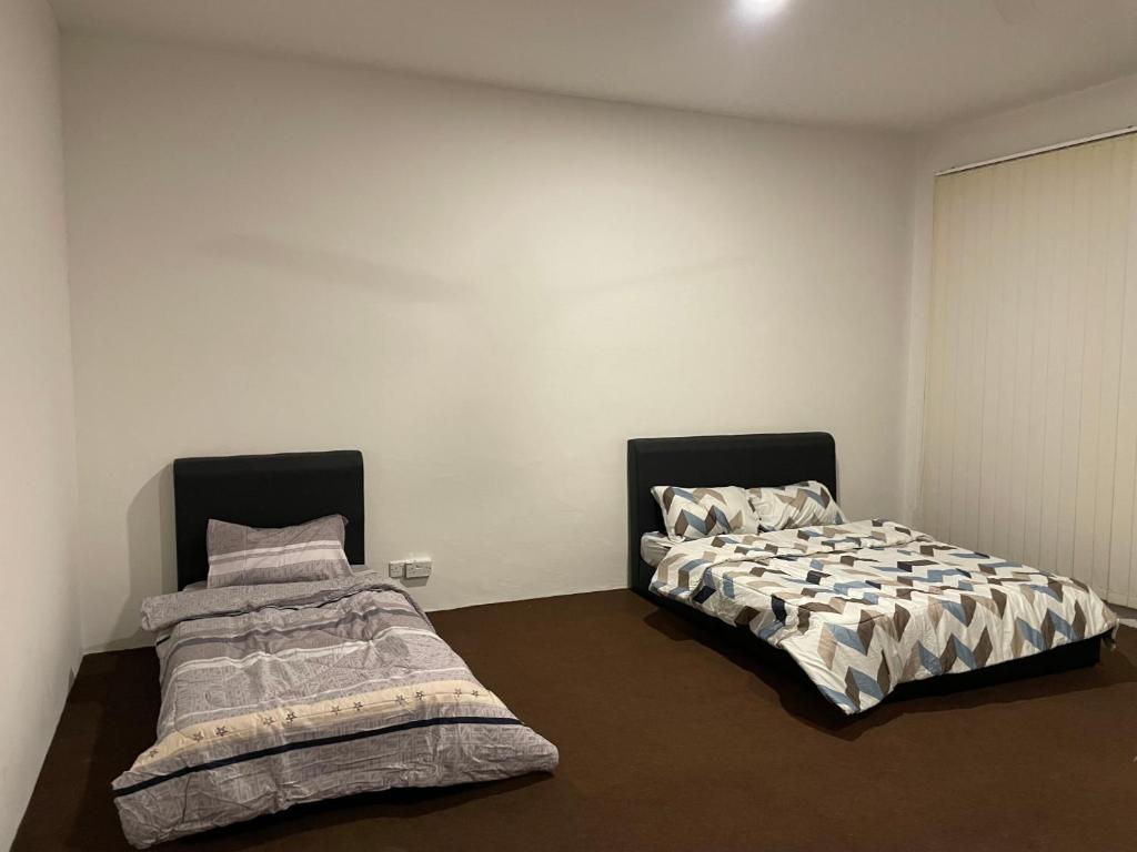 拿笃ML Homestay的两张睡床彼此相邻,位于一个房间里
