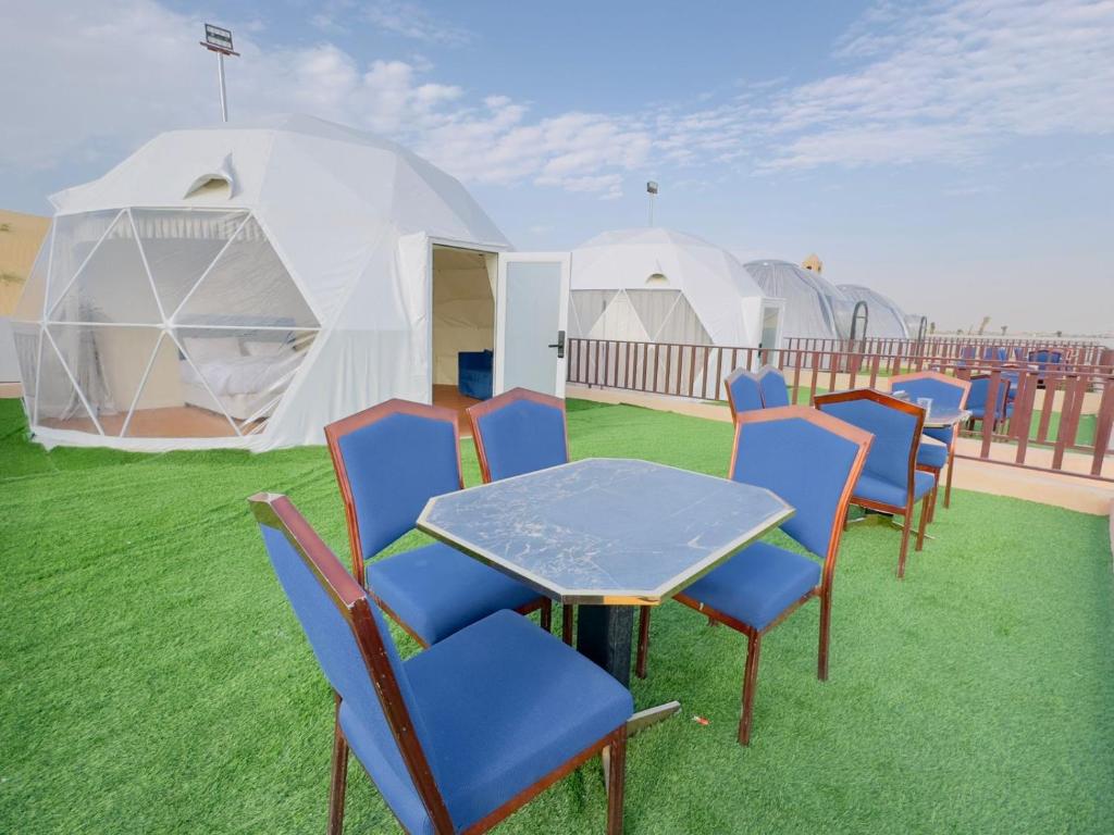 HunaywahDesert Safari Dubai Over Night Stay的一组椅子和一张桌子以及一些帐篷
