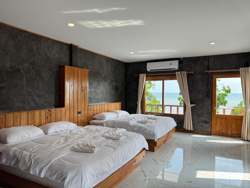 利邦岛Libong Loft Home的带2扇窗户的客房内的2张床