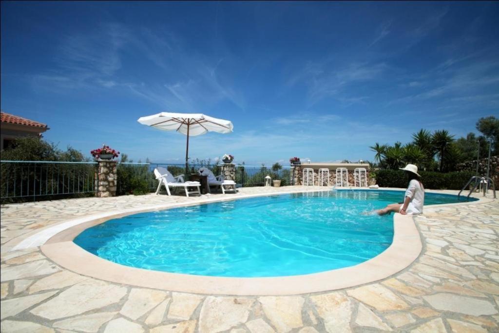 苏卡雷斯埃勒尼亚别墅酒店的一个人站在游泳池旁边