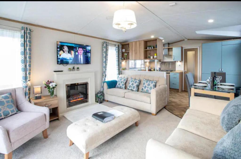 圣安德鲁斯Beautiful 3-Bed Lodge in St Andrews的客厅设有两张沙发和一个壁炉