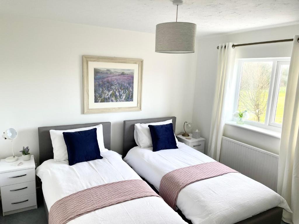 拉内利Comfortable and Spacious Superb Holiday Home in Llanelli, Dog Friendly的白色和蓝色的客房内的两张床