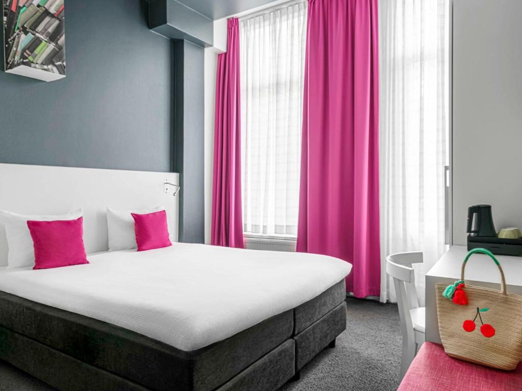 阿姆斯特丹宜必思风格阿姆斯特丹阿姆斯特尔酒店的一间卧室配有一张带粉红色窗帘的大床