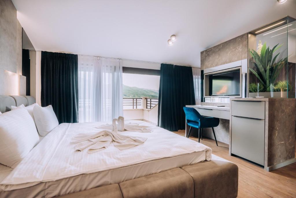 奥赫里德阿勒克桑德丽亚酒店的一间卧室配有一张大床、一张桌子和一张书桌