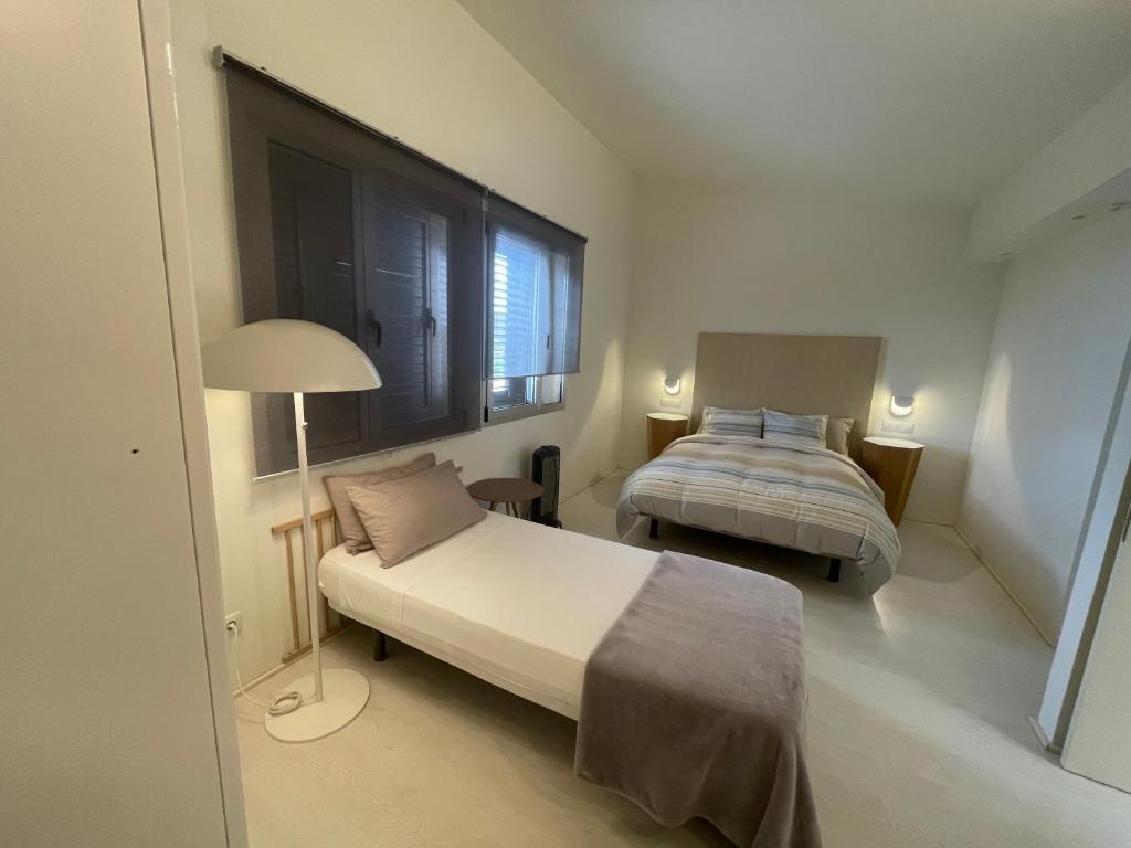 大加那利岛拉斯帕尔马斯Villa con piscina privada Palmeras Home的一间卧室配有两张床和一盏灯。
