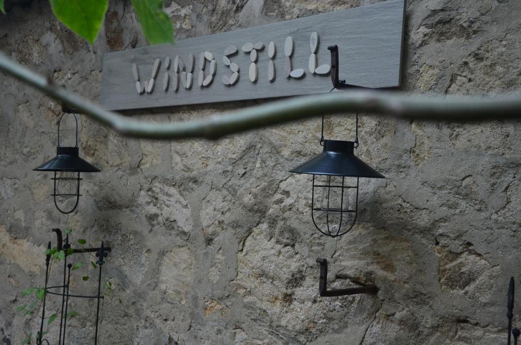 拉斯特Windstill Apartments的石墙上挂着三个灯,上面有标志