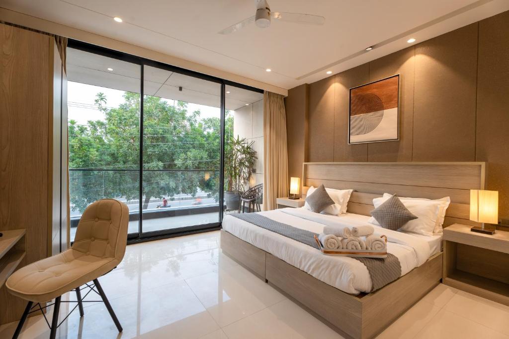 古尔冈The Lodgers Luxury Hotel Near Golf Course Road Gurgaon的一间卧室设有一张大床和一个大窗户