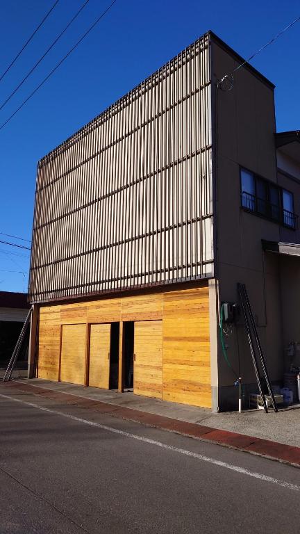 藤里町白神山地の麓でヤギのいるゲストハウス　あわじ商店的街道边的木门建筑