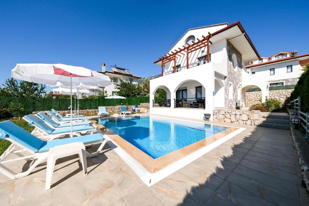 费特希耶Turquoise Shores Family-Friendly Luxury Villa Fethiye Oludeniz by Sunworld Villas的一座带游泳池和房子的别墅