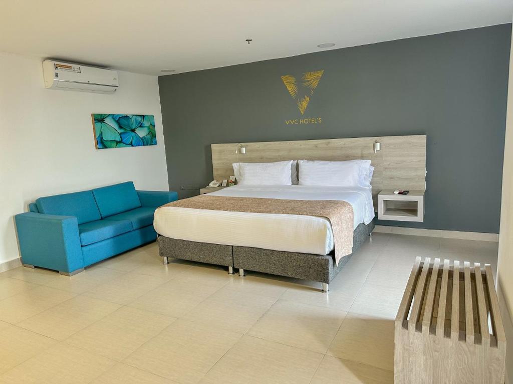 比亚维森西奥VVC Hotel's的一间卧室配有一张床和一张蓝色的沙发