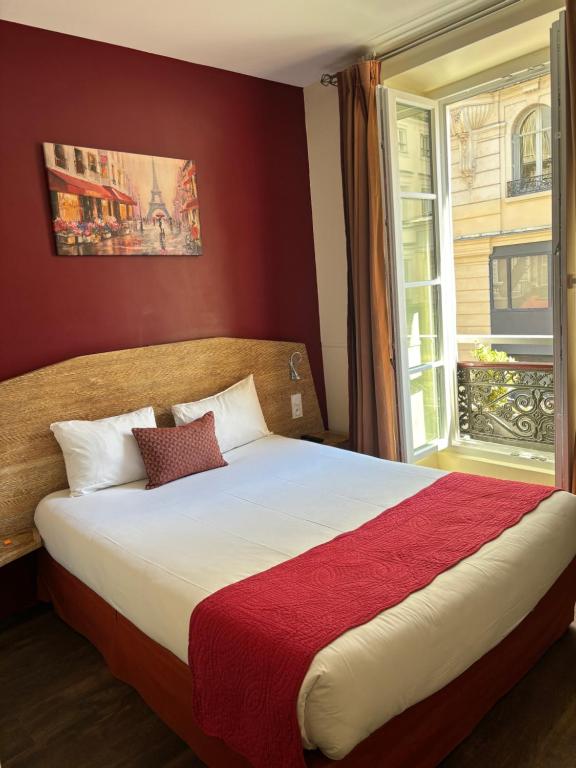 巴黎穆兰广场酒店的一间卧室设有一张大床和窗户
