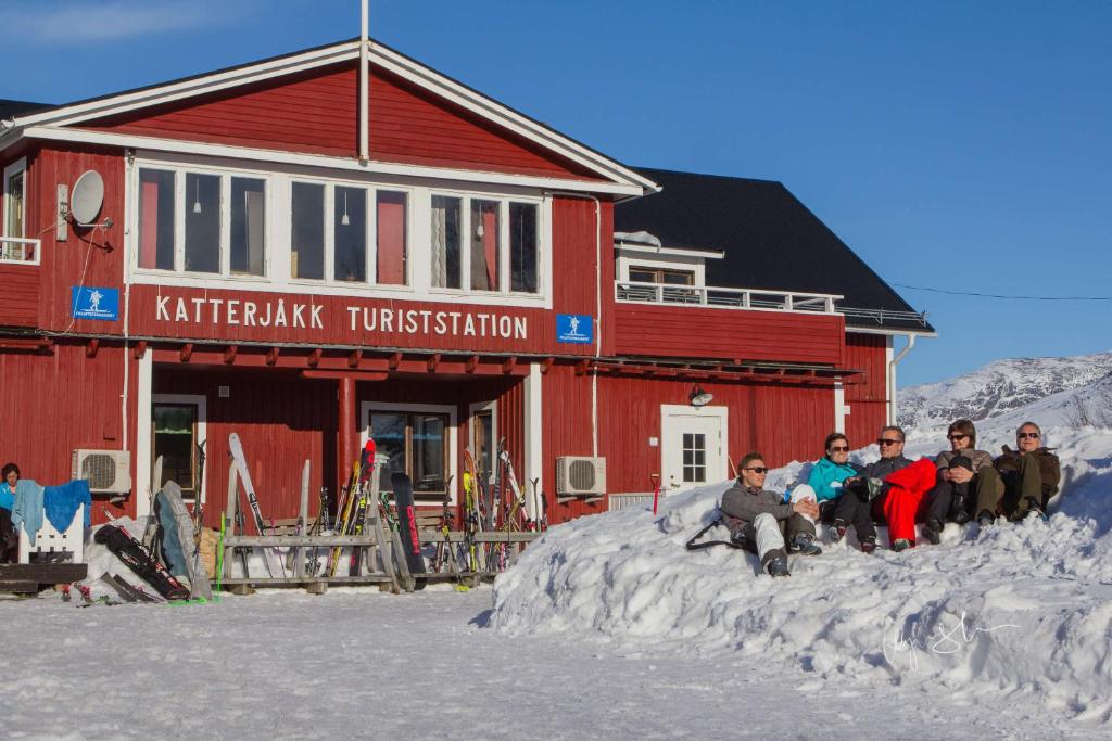 里克斯格伦森卡特约克旅游旅舍的一群人坐在大楼前的雪中