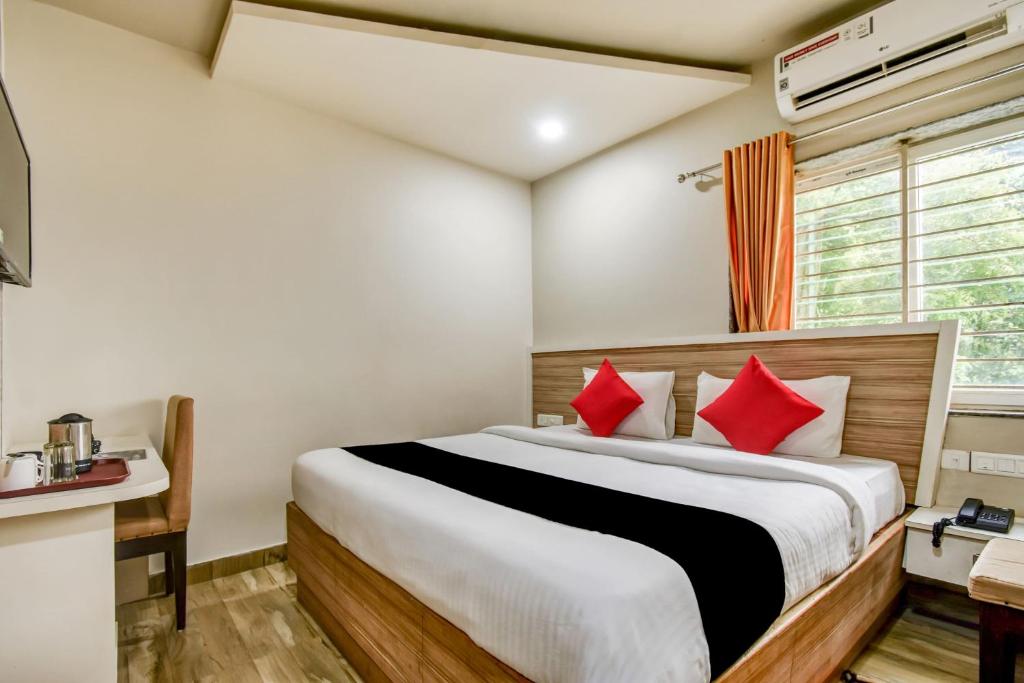 布巴内什瓦尔Super Collection O 75732 Hotel Aatithya的一间卧室配有一张带红色枕头的大床