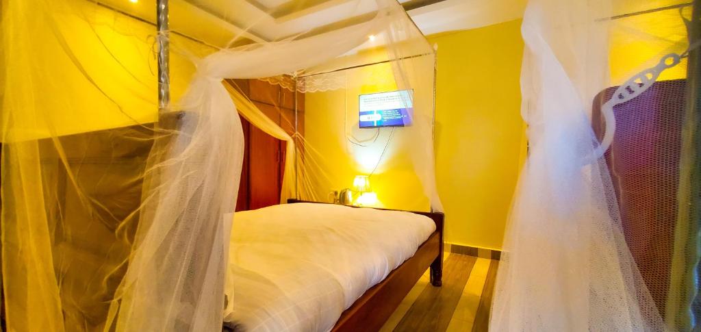 LiraArmaflex Hotel Lira的一间卧室配有一张带婚礼纱的天蓬床