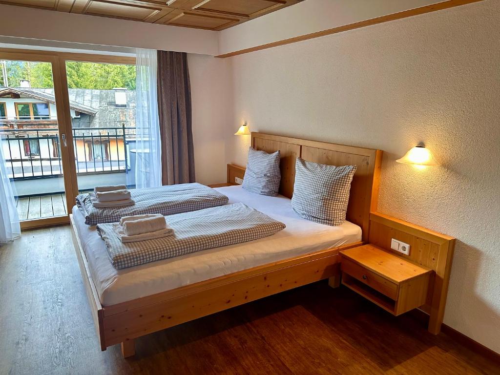 洛伊塔施汉德尔公寓酒店的一间卧室设有两张床和窗户。