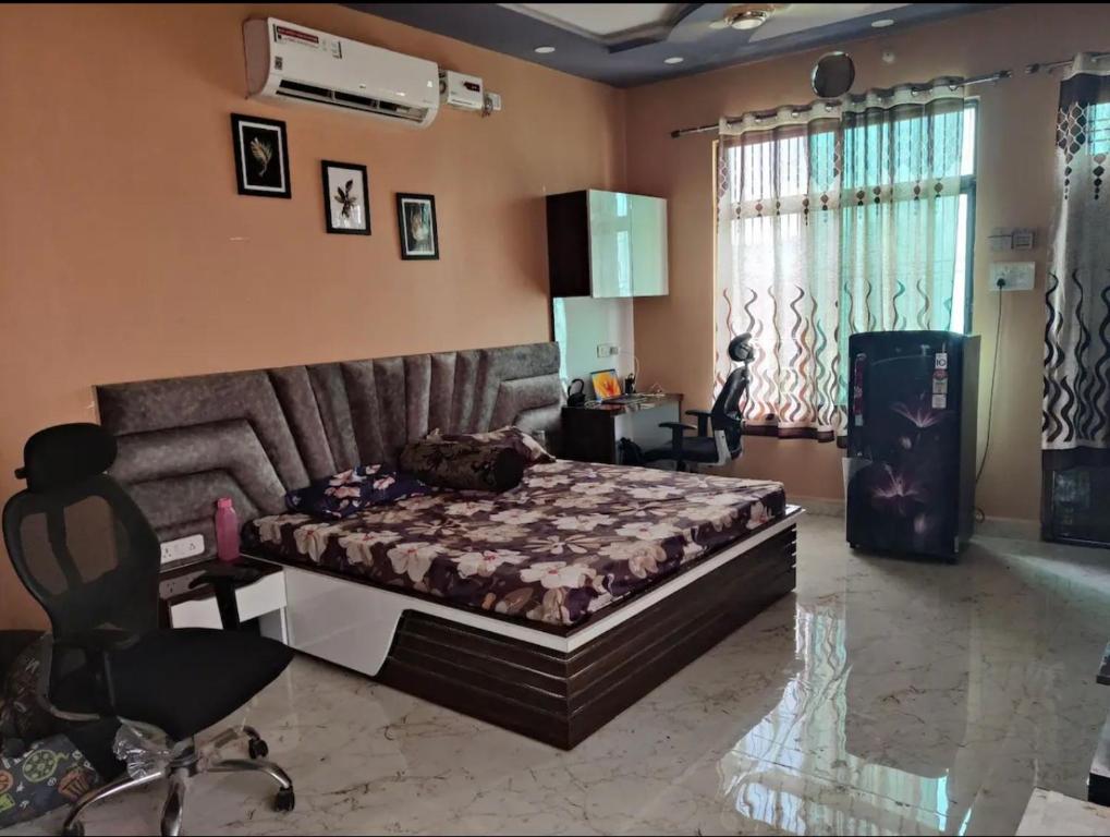 瓜廖尔Your Own Sweet Nest in Gwalior with comfort的一间卧室配有一张床、一张桌子和一把椅子