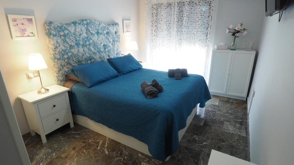 阿尔巴塞特Bonito apartamento en centro ciudad con garaje的一间卧室配有一张蓝色的床,上面有一双鞋