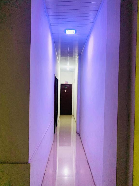 LamnyongSEUNIA HOTEL的一条带紫色墙壁的走廊和一个带门的走廊