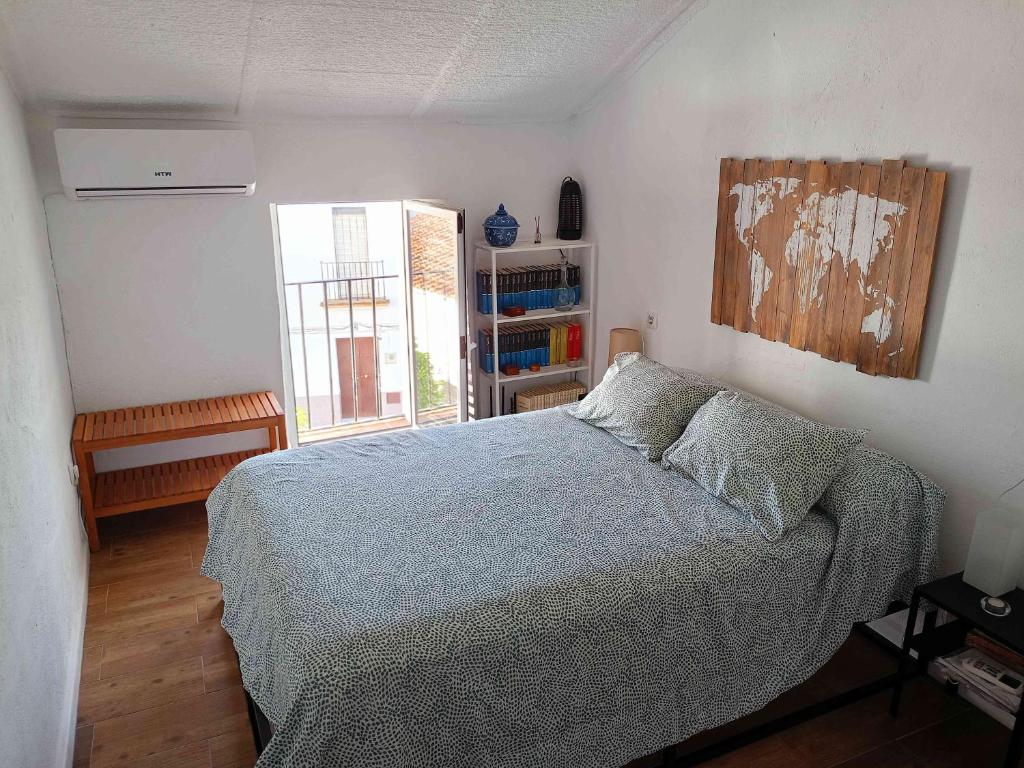 埃尔佩德罗索Casa Rural El Palomar的一间卧室设有一张床和一个书架