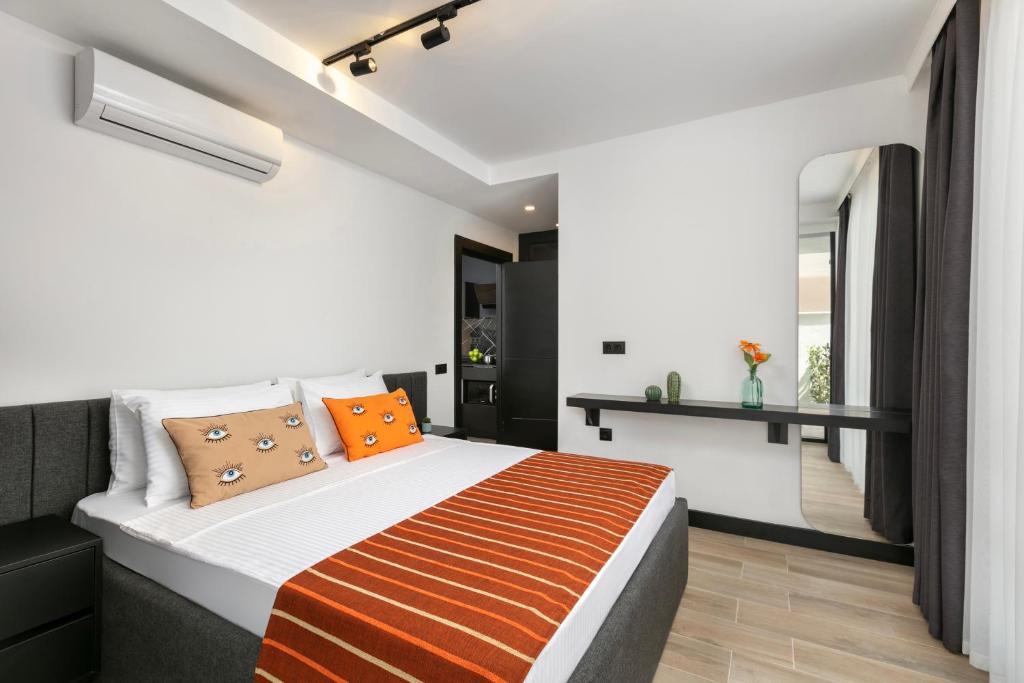 安塔利亚Ella Suites Hotel的一间卧室配有一张带橙色枕头的大床