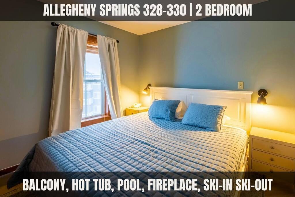 斯诺肖Allegheny328, Hot Tub, Pool, Ski InOut, Village的一间卧室配有一张带蓝色床单的床和一扇窗户。