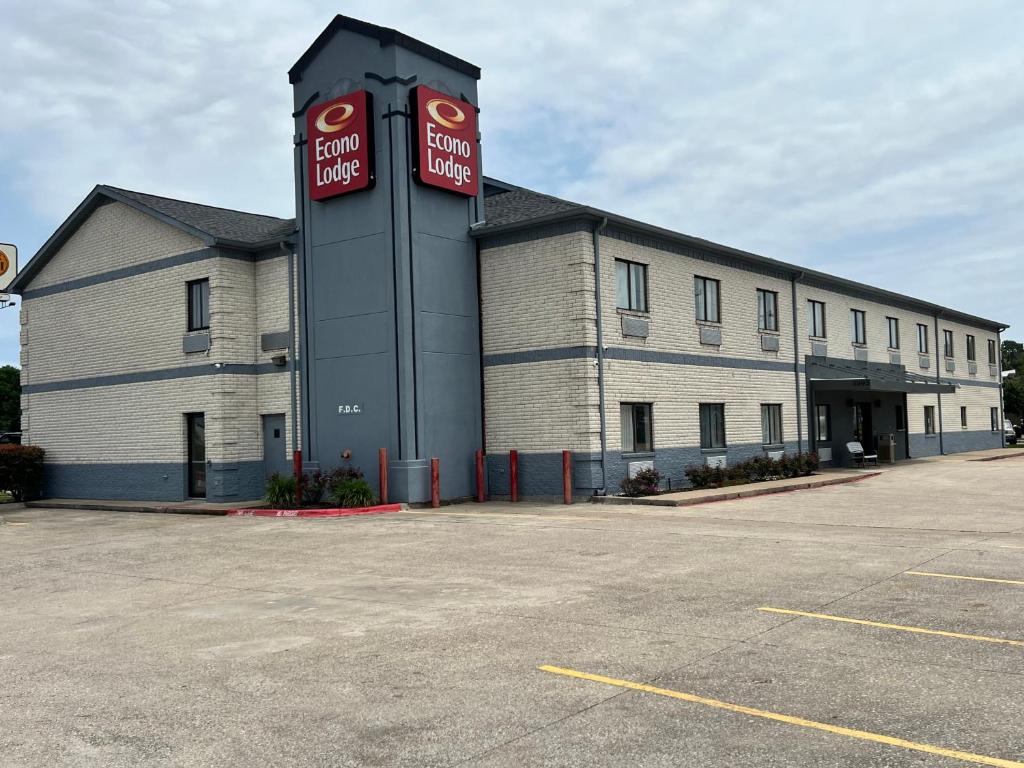 博蒙特Econo Lodge Beaumont I-10 South的一座白色的大建筑,上面有两个红色的标志