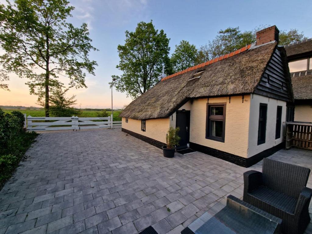 RyptsjerkBed en stal 'Het Woudhuisje'的茅草屋顶和庭院的房子