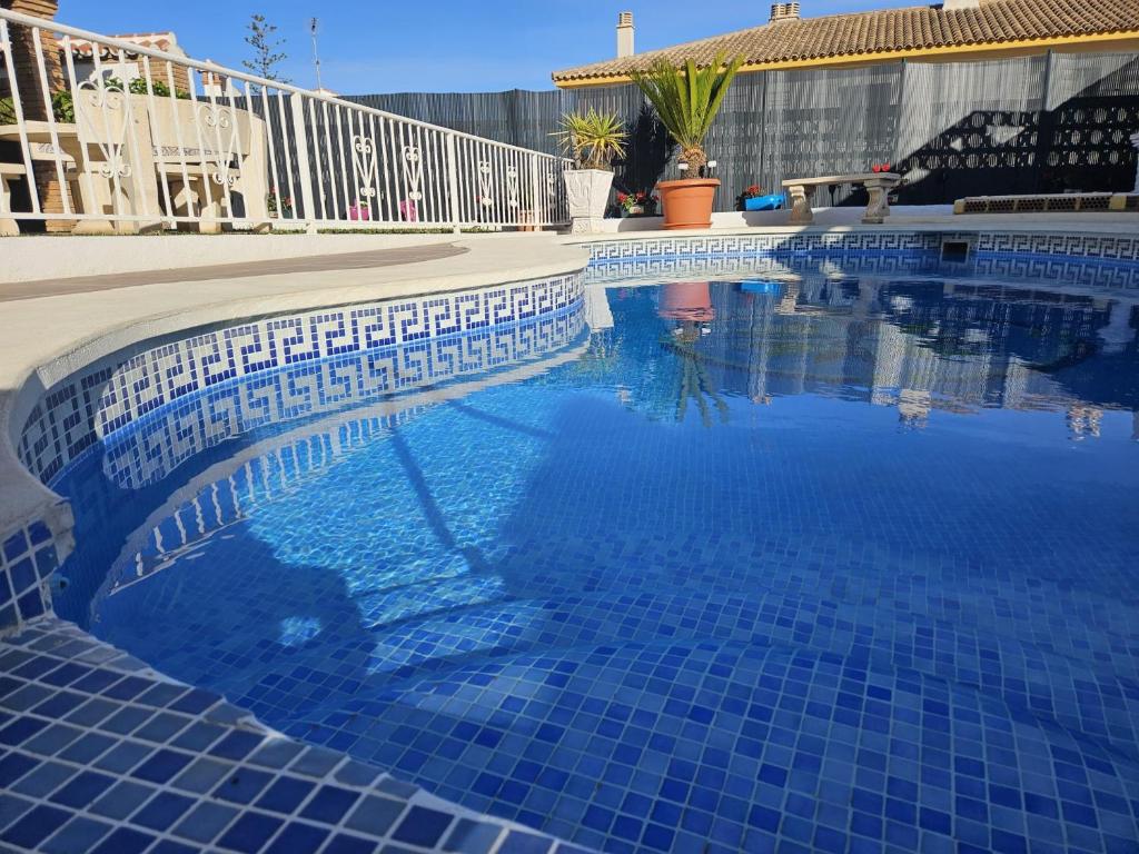 阿罗约德拉迷雅Villa Tony - Benalmádena的一个带蓝色瓷砖地板和围栏的游泳池