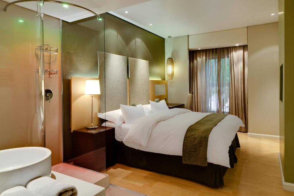 布隆方丹布隆方丹柳树湖万豪Protea酒店的一间卧室设有一张大床和一个浴缸