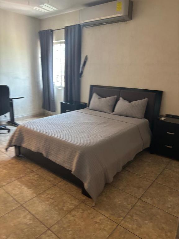 萨尔蒂约Habitación Roble的一间卧室配有一张带蓝色窗帘的大床