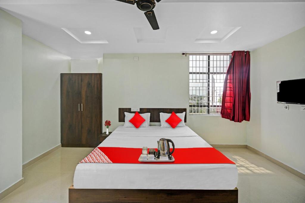 KurmannapalemOYO VRK Residency的一间卧室配有一张带红白毯子的床