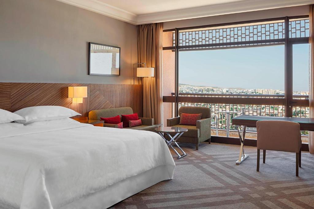 突尼斯突尼斯喜来登酒店的酒店客房设有一张大床和一张书桌。