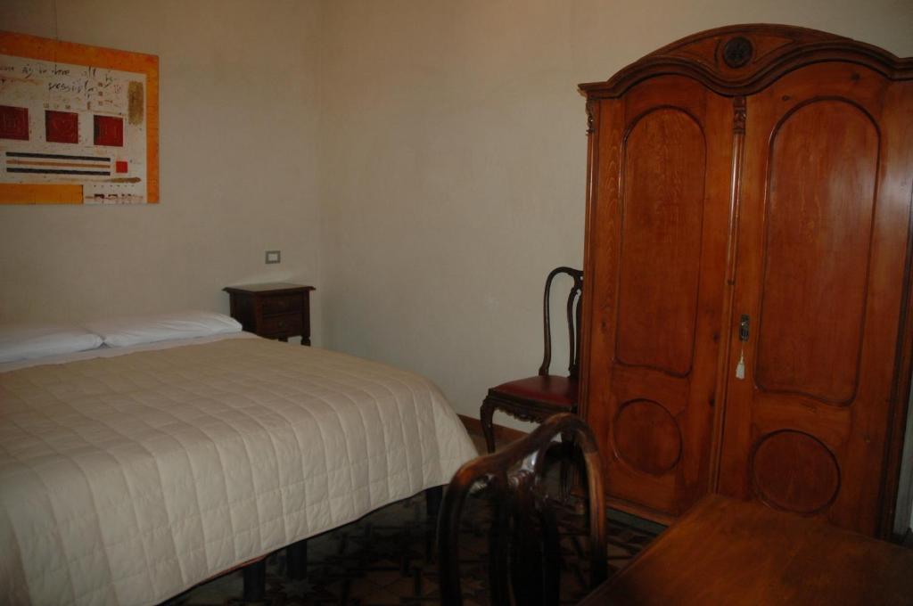 维罗纳勒马大雷那住宿加早餐旅馆的一间卧室配有一张床和一个木制橱柜