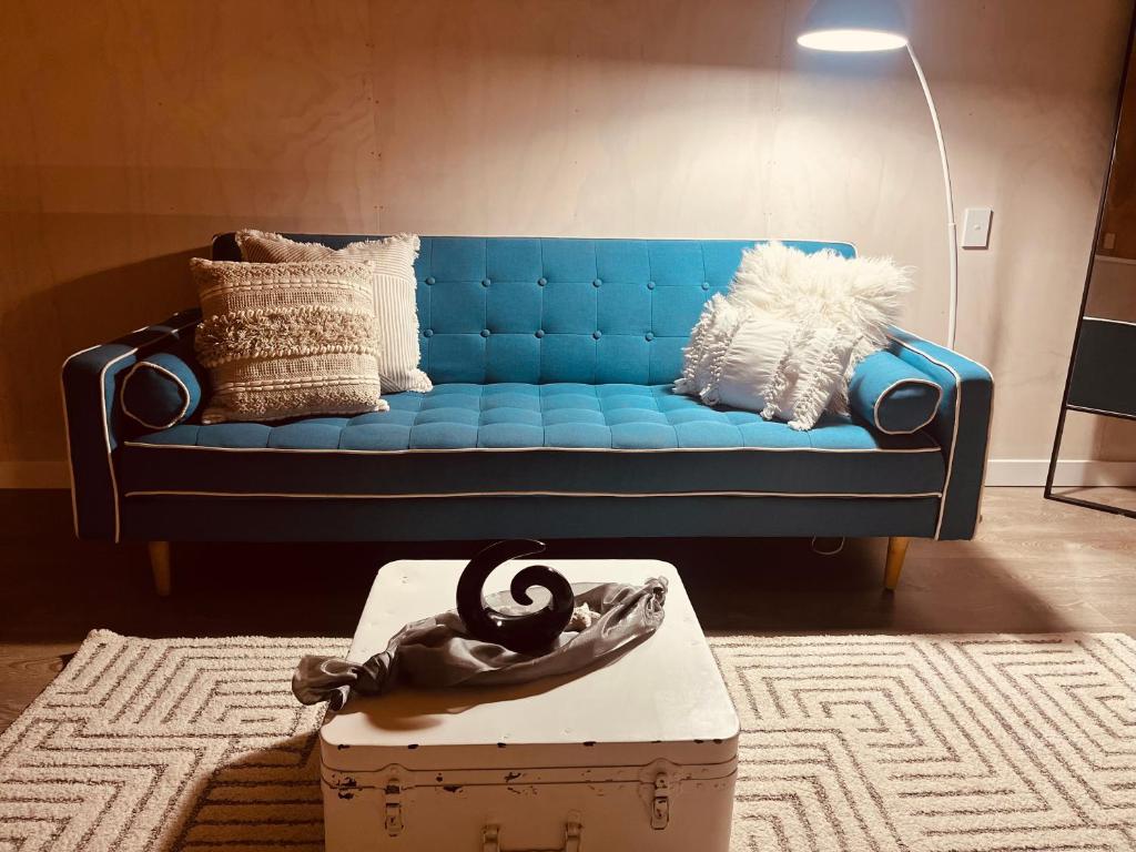 RivertonVitamin Sea Beach House的客厅里一张蓝色的沙发,配有盒子