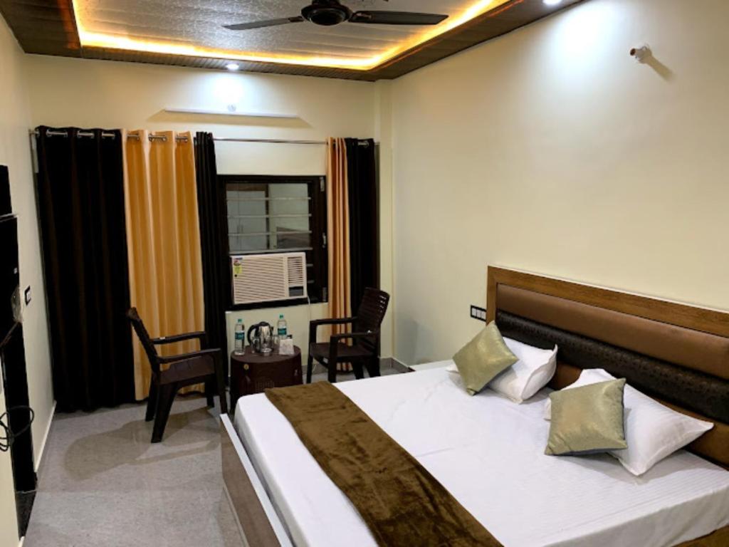 哈里瓦Goroomgo Tapovan Residency Haridwar - Excellent Service Recommended的卧室配有一张床和一张桌子及椅子