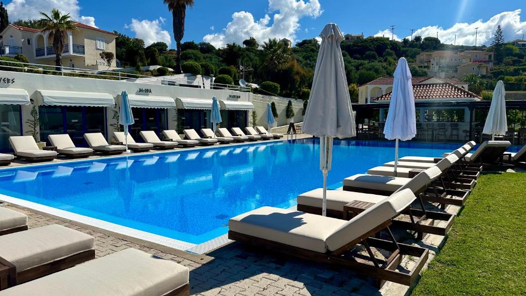 拉瑟解放村公寓式酒店的一个带躺椅和遮阳伞的游泳池
