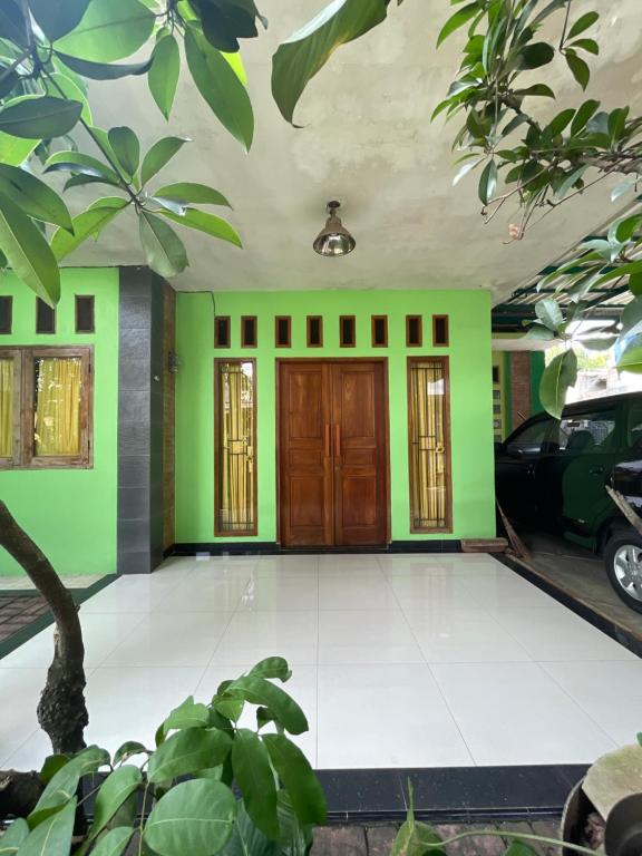Green House Rawageni的一间设有绿色墙壁和木门的房间