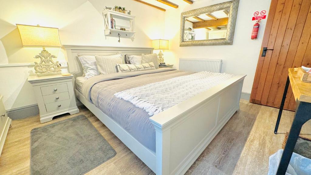 彭里斯Swallow Barn的卧室配有一张白色大床和镜子