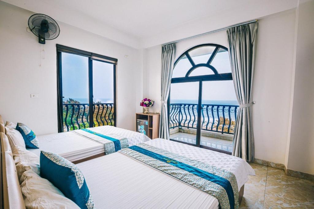 岑山Hương Lý Hotel的带大窗户的客房内的两张床