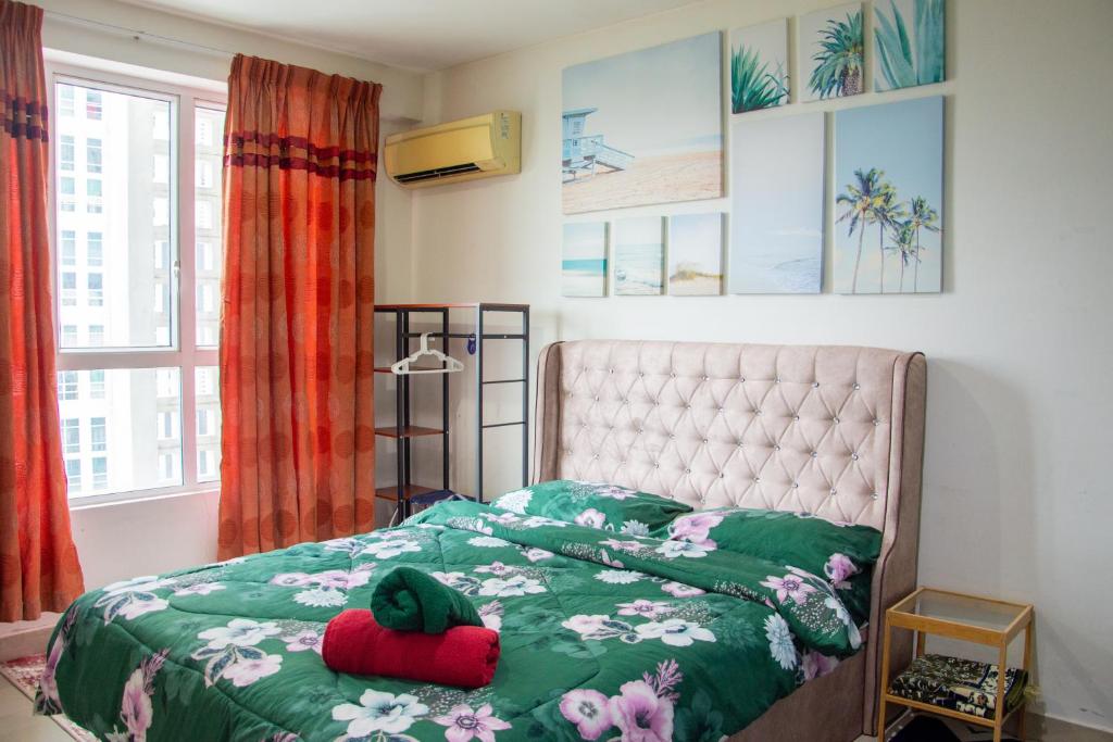 莎阿南Homestay at Menara U的一间卧室配有一张带绿色棉被的床