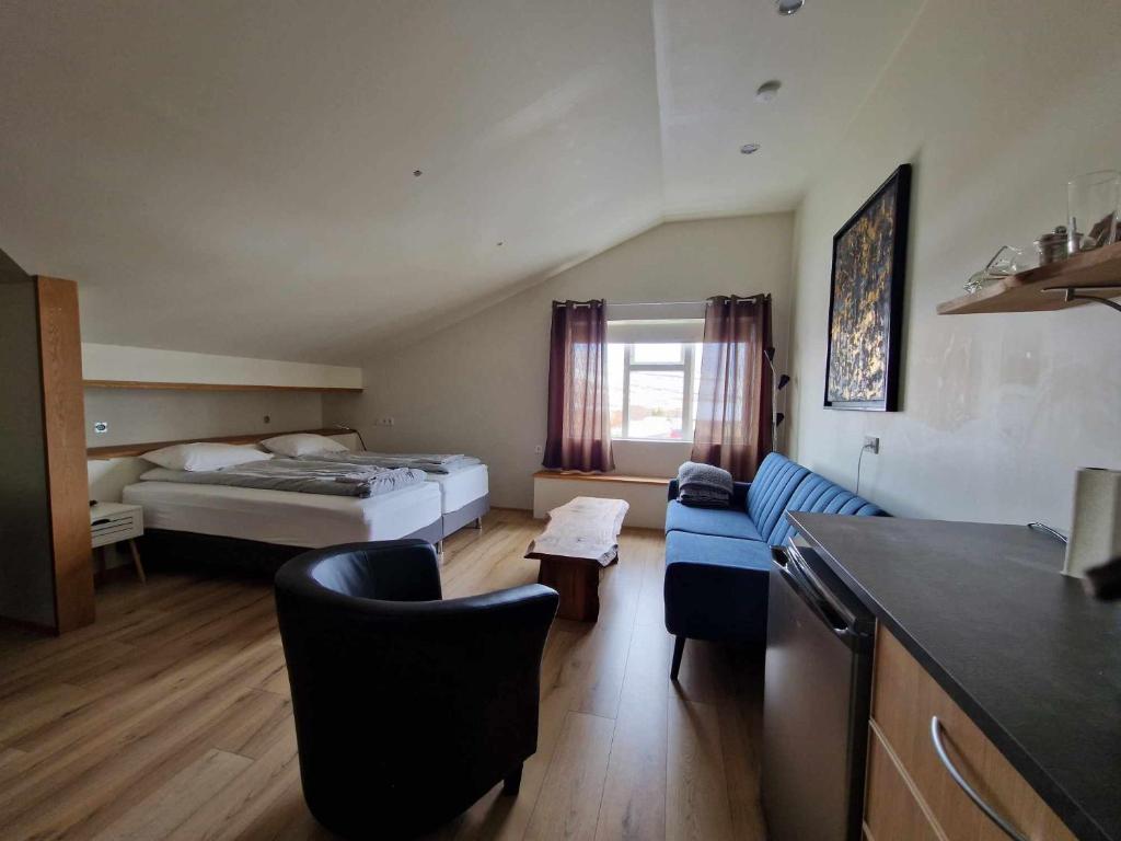 KaldrananesSvansholl Apartments的酒店客房,配有床和蓝色的沙发