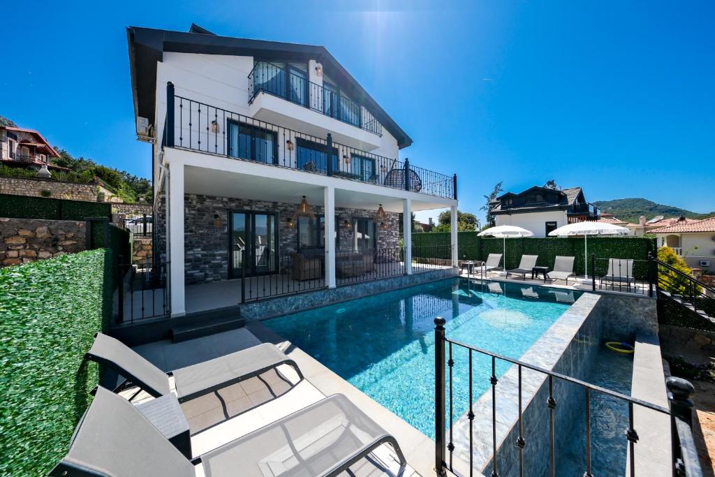 费特希耶Oasis Family-Friendly Luxury Villa Fethiye Oludeniz by Sunworld Villas的一座带游泳池和房子的别墅