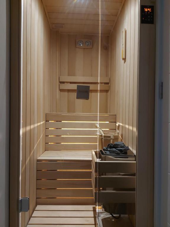 Novi BeogradPiano Luxe Apartment with Sauna的步入式淋浴间设有木墙和木架