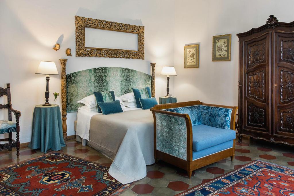 莫内利亚阿巴迪亚圣乔治酒店的一间卧室配有一张床、一把椅子和镜子