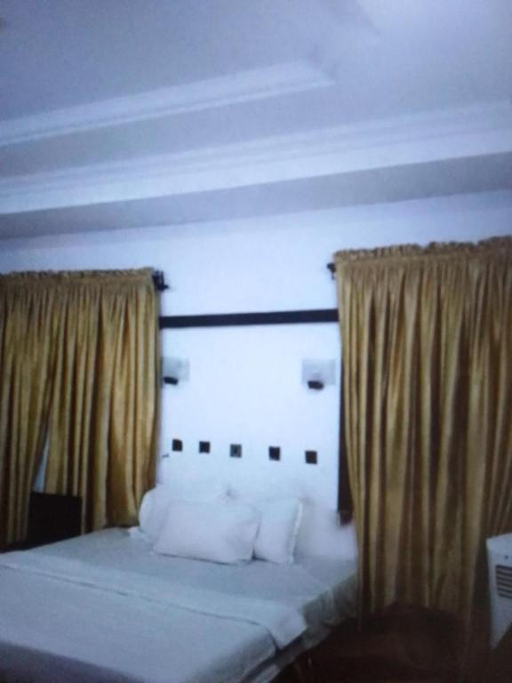 拉各斯N.V HOTEL AND RESORT BEACH view的一张带白色枕头和窗帘的床