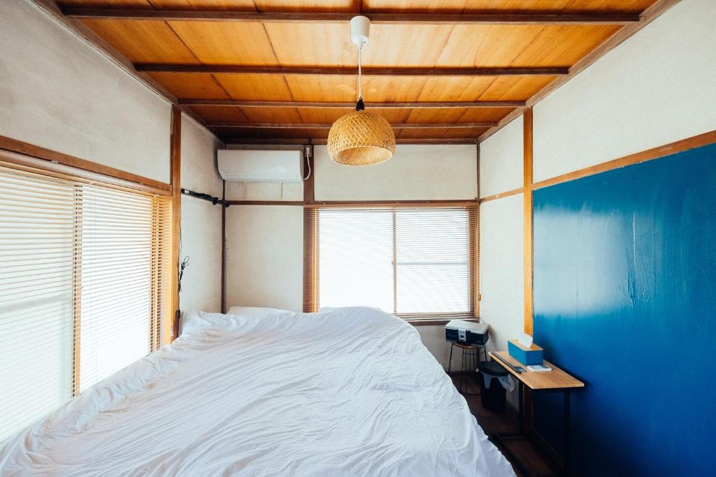 松本松本市の一棟貸し切りできる古民家的一间卧室设有一张大床和蓝色的墙壁