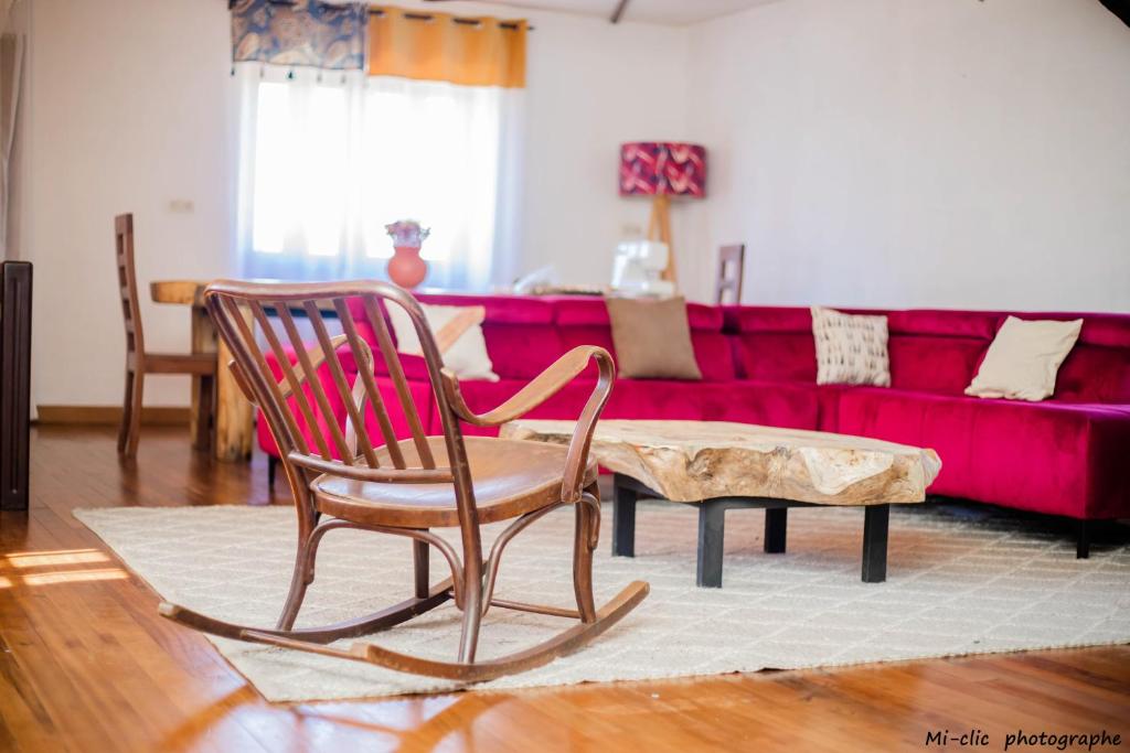菲亚纳兰楚阿MANGA BLUE'S GUEST HOUSE的客厅配有红色沙发和2把摇椅