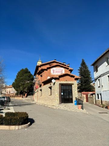 Torres de AlbarracínHotel El Cid的一座小砖砌建筑,上面有标志