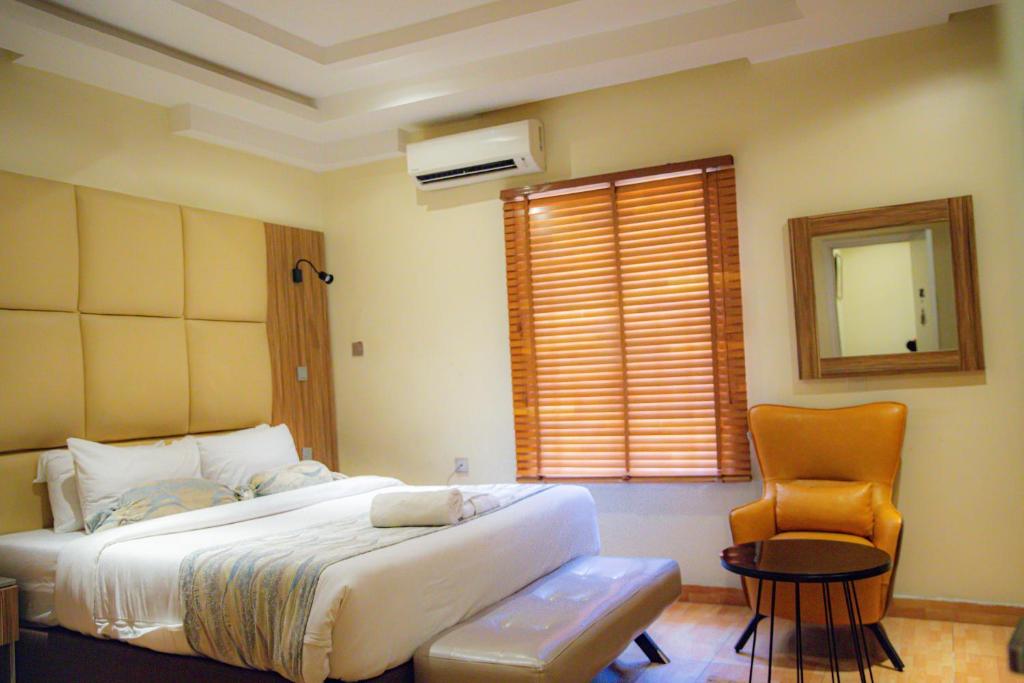 拉各斯Box Residence Hotel的卧室配有床、椅子和窗户。