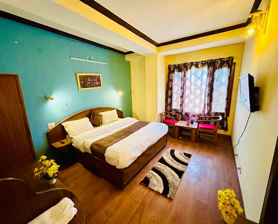 西姆拉Hotel Tara Regency - A family Hotel的一间卧室设有一张大床和一个窗户。